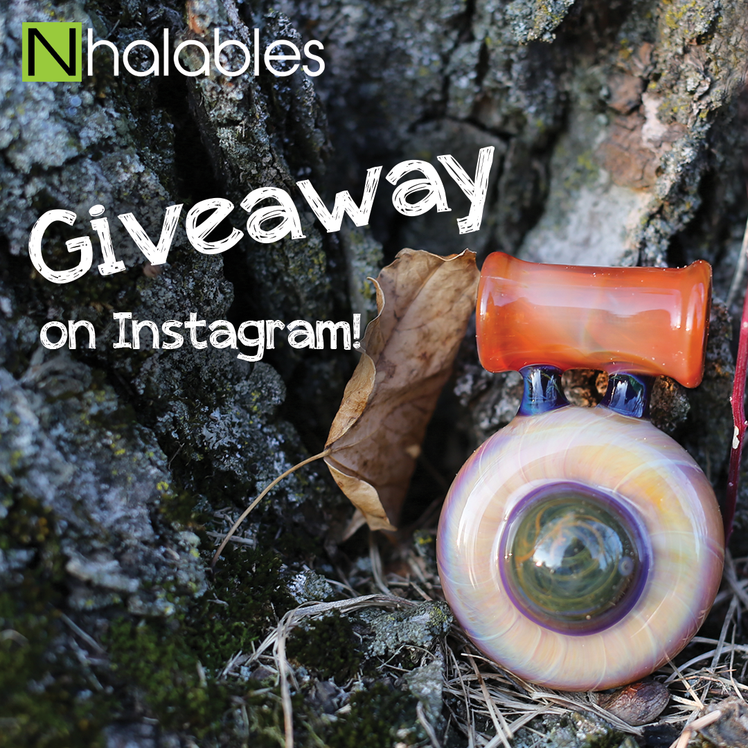 Nhalables Social Post showing a seredipity colored glass pendant by Akron, Ohio based artist Eyehole Glass. Its sitting by a stump with a leaf next to it. And has the text Giveaway on Instagram written next to it.