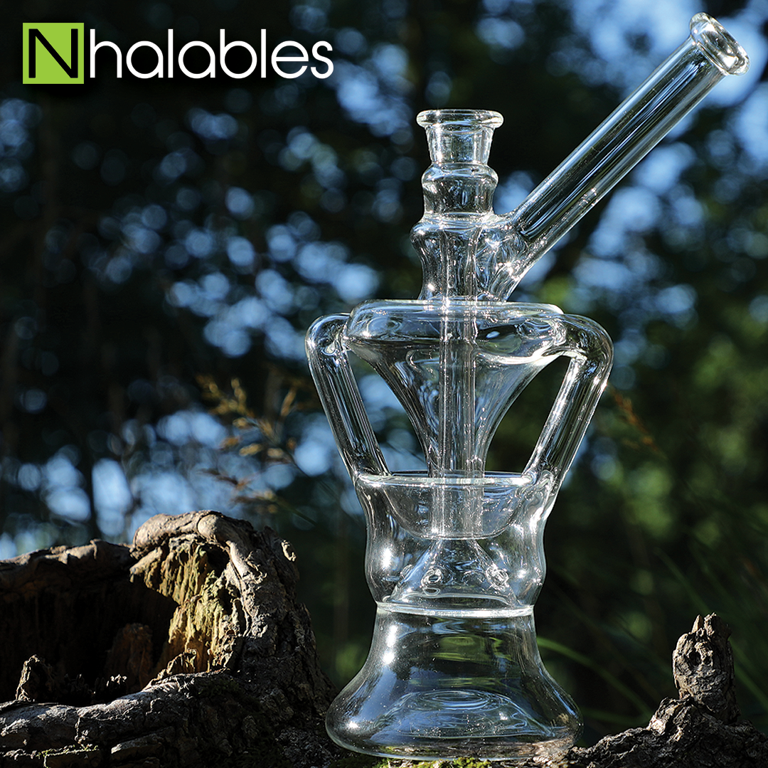 Nhalables Social Post showing a Cleveland Based artist Bronztucky Glass - Centrifuge Recycler sitting on a wooden log with trees in the background