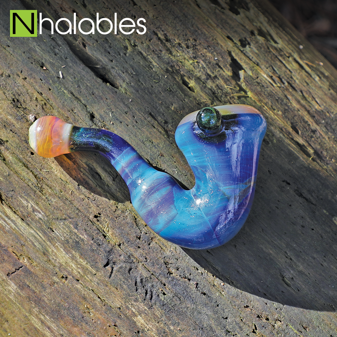 Nhalables Social Post showing a Blue Sherlock Handpipe by Akron, Ohio based Eyehole Glass sitting on a wooden log