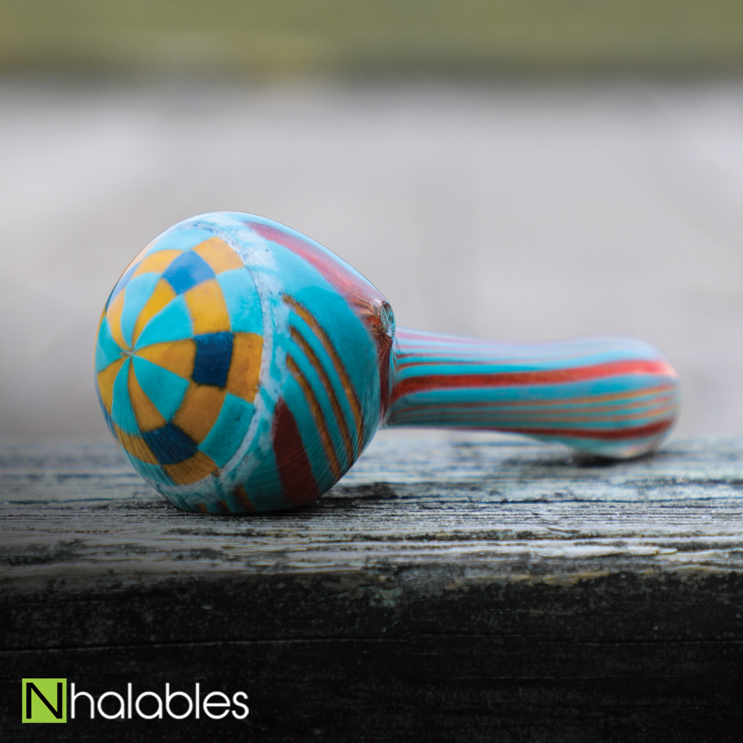 Nhalables Social Post for a Checker Spoons/Hand pipes by Michigan Based Glassblower Hoffman Glass (Steven) sitting on a wooden bridge with some blurry grass in the background 