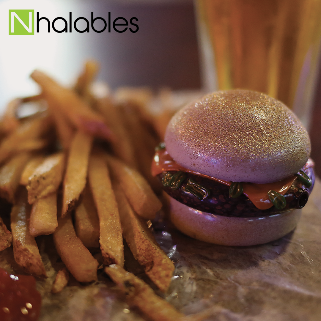 Nhalables Social Post showing a Rosburg Glass Burger Spoon sitting on a brown bag with French Fries and A Beer in the background.